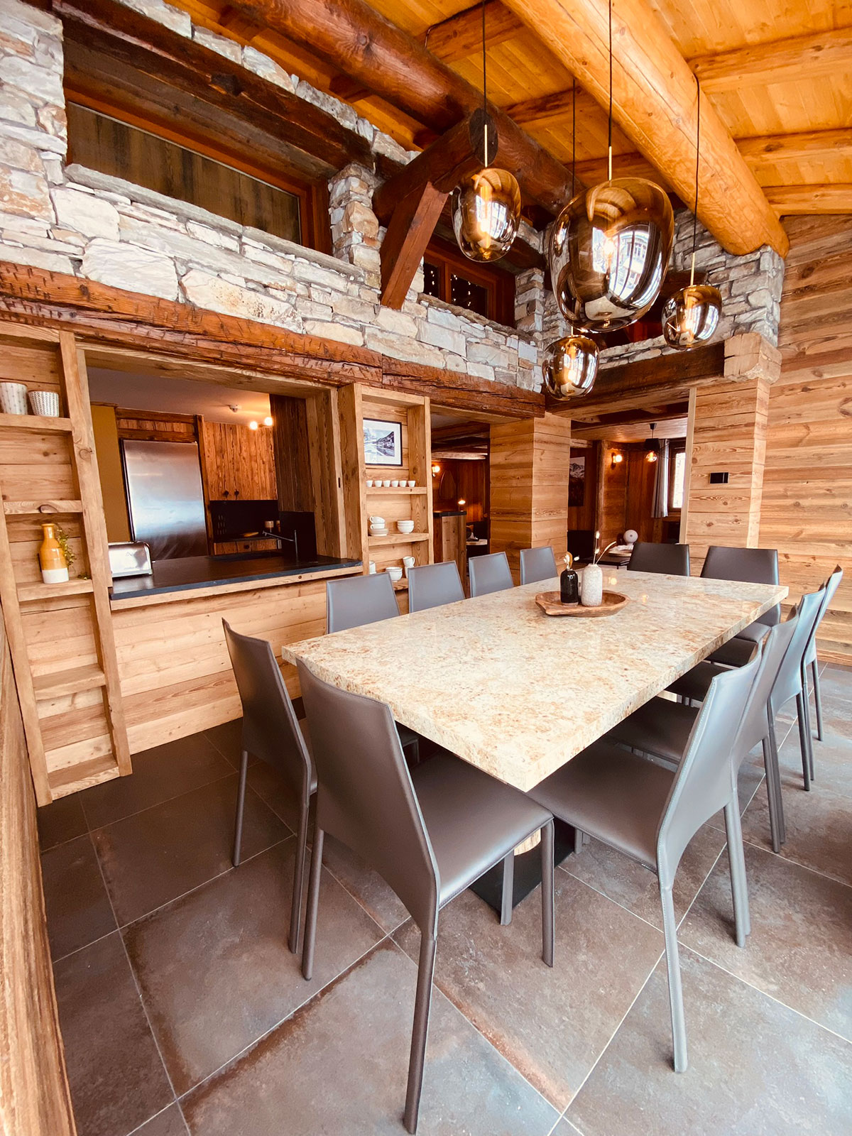 Wide view of the chalet dining room, wood and stone interior