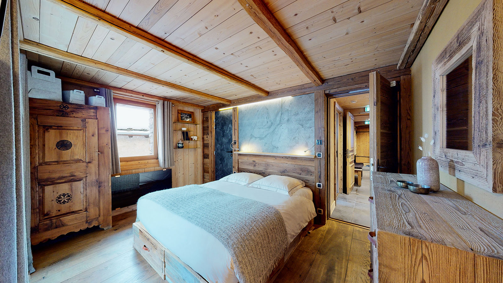 Ground-floor suite at Chalet La Marsa — sleeping area with double bed and refined alpine decor, Val d'Isère